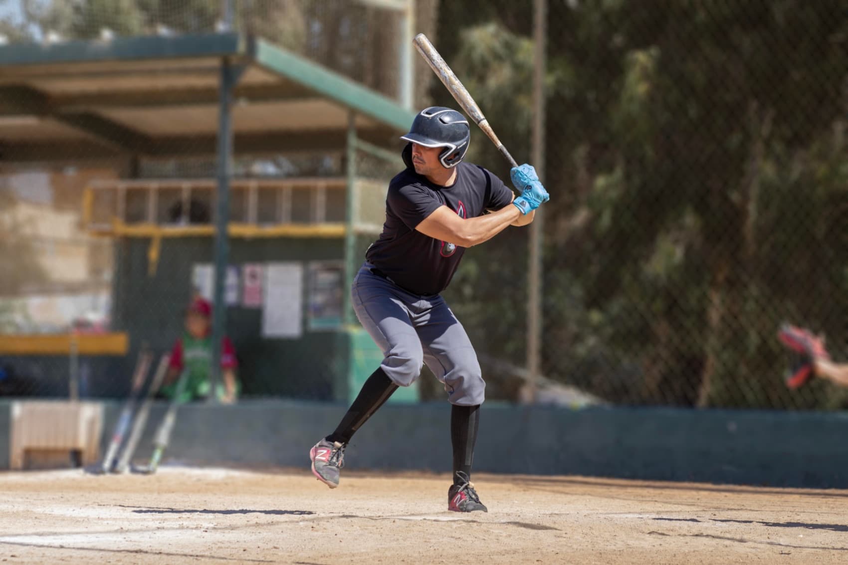 Batter waiting on the pitch in team uniform