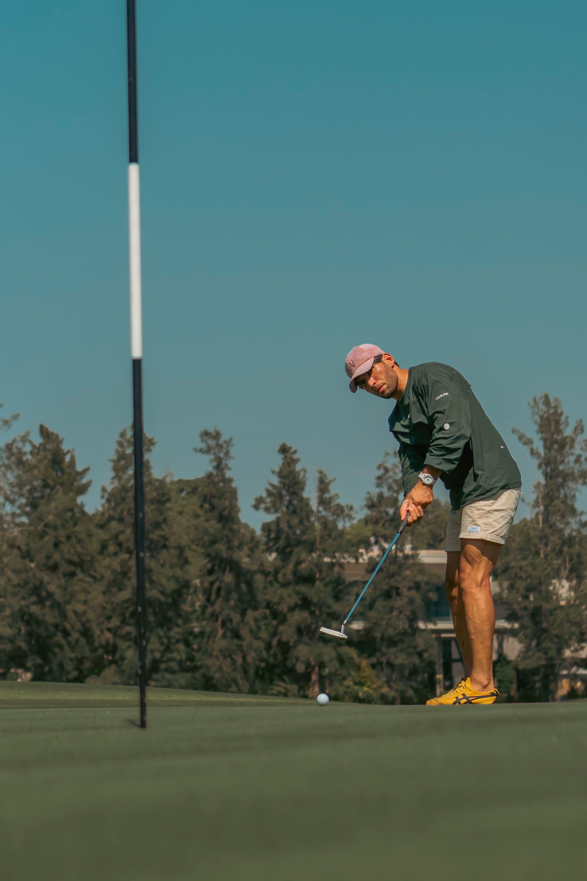 Golfer putting on the green in branded layers