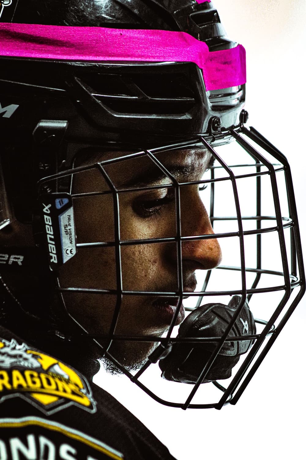 Hockey player in a caged helmet on the bench