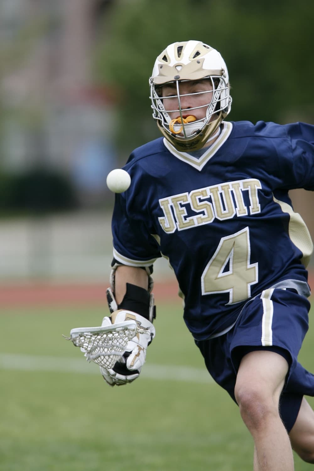 Lacrosse player running with the ball in the air