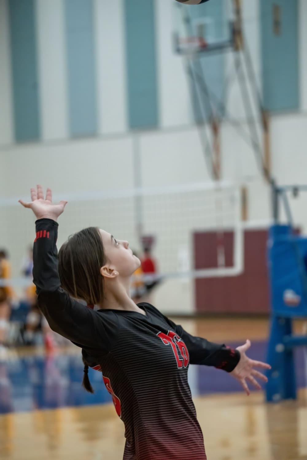 Volleyball player serving in a team jersey