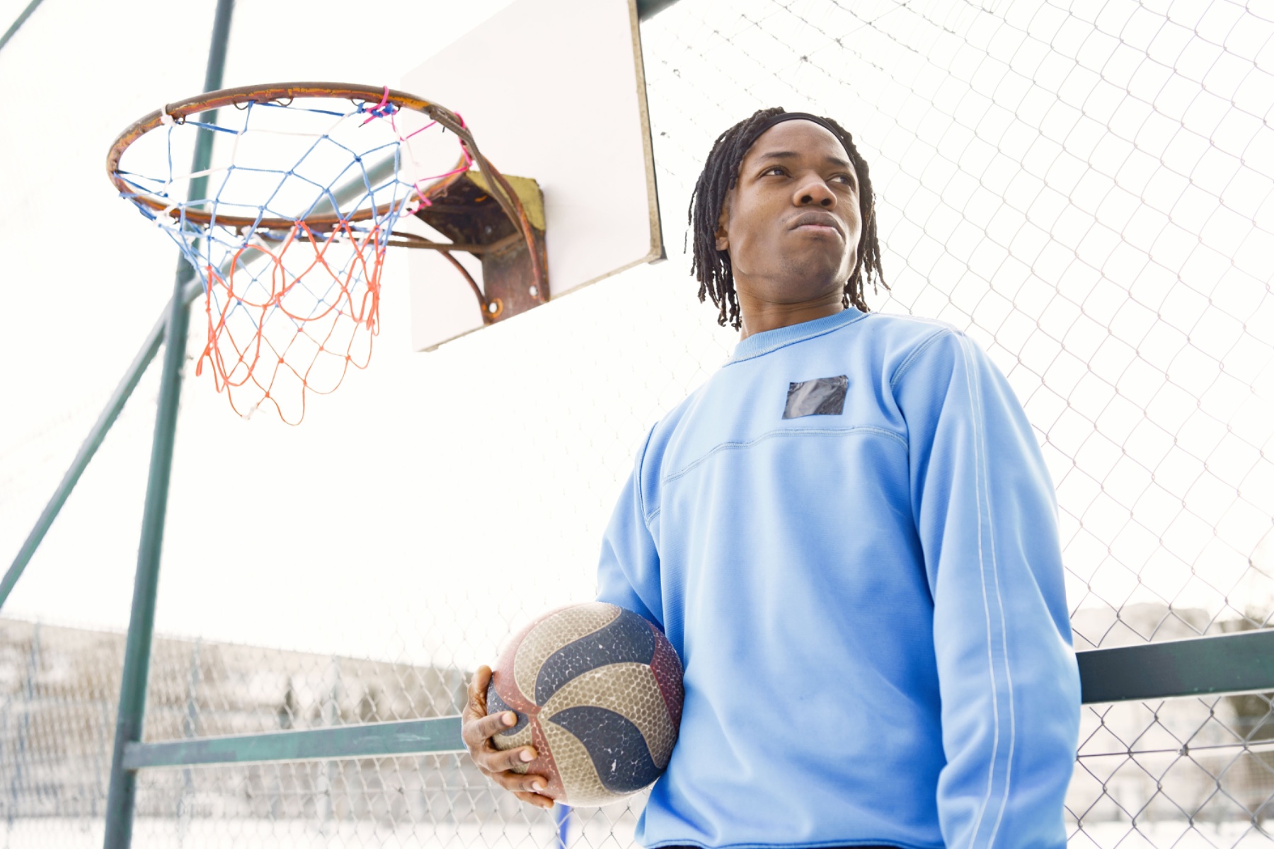 Basketball player in a custom crewneck holding a ball under the hoop