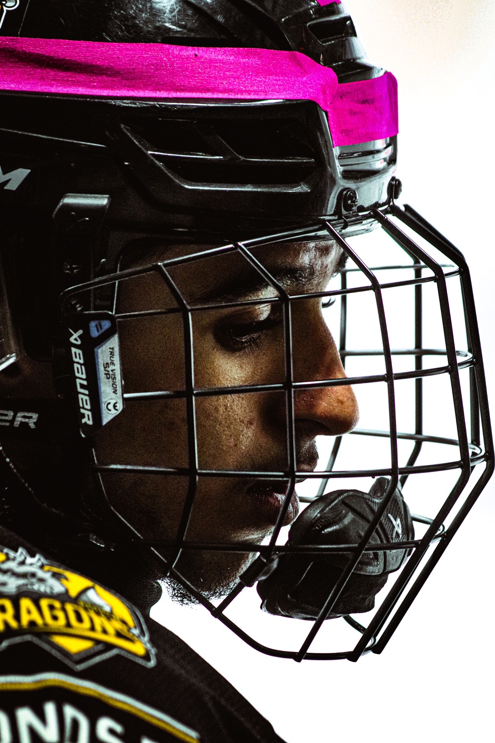 Hockey player in a caged helmet on the bench
