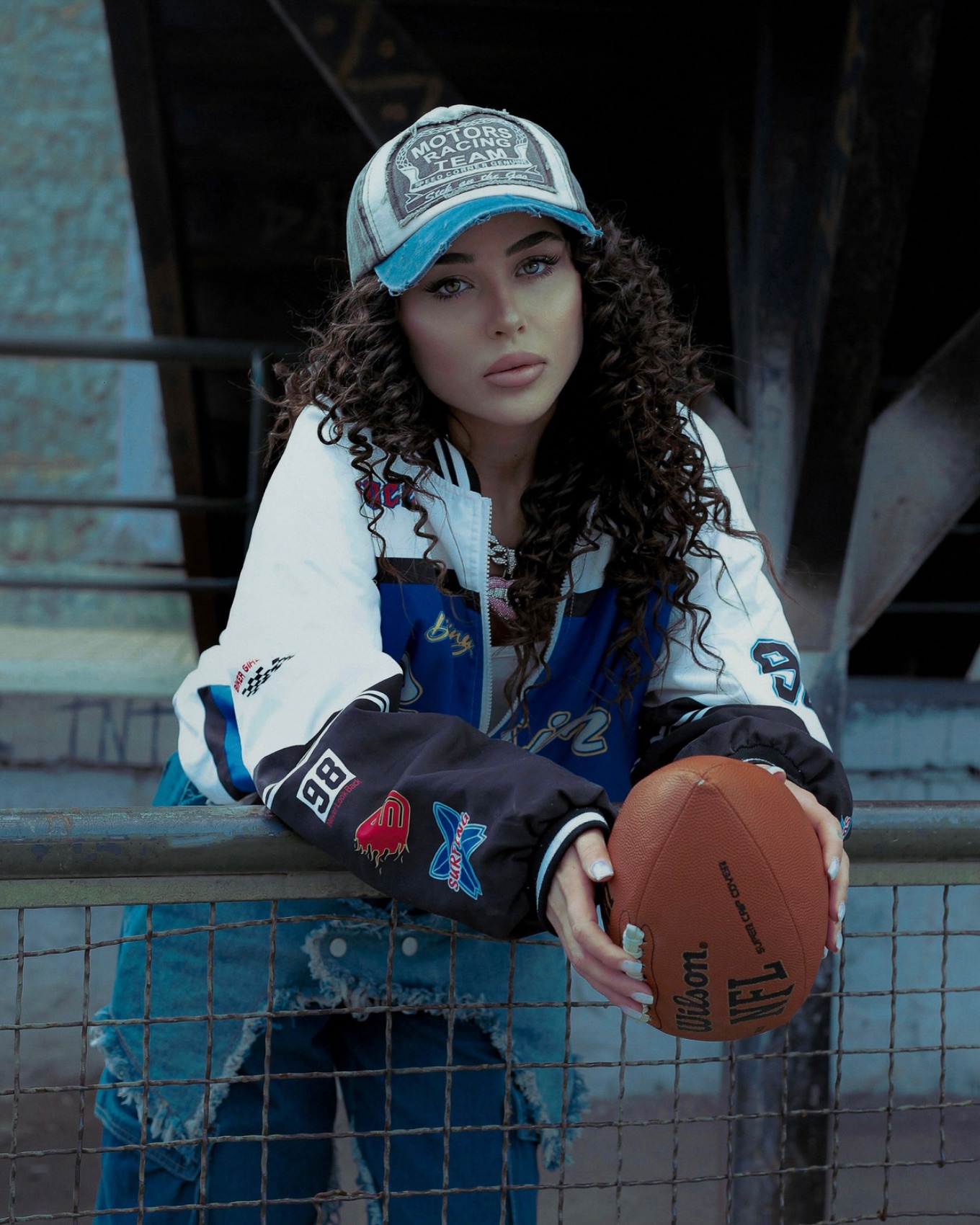Person wearing a printed varsity-style jacket and cap